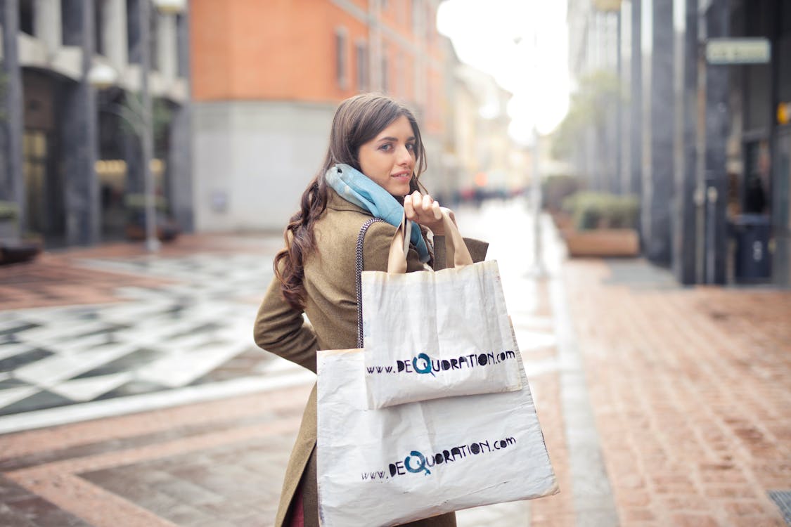 Free Woman in Brown Coat Carrying Two White Tote Bags Stock Photo