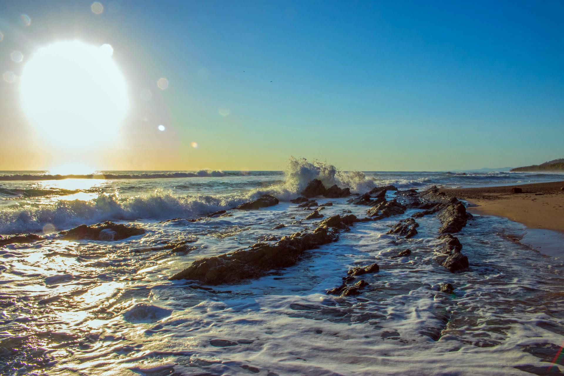A captivating view of waves crashing on the rocky shore at sunset in Puntarenas, Costa Rica.