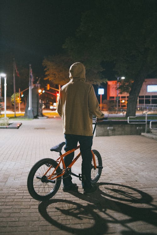 Person Wearing a Hoodie Riding a Bicycle