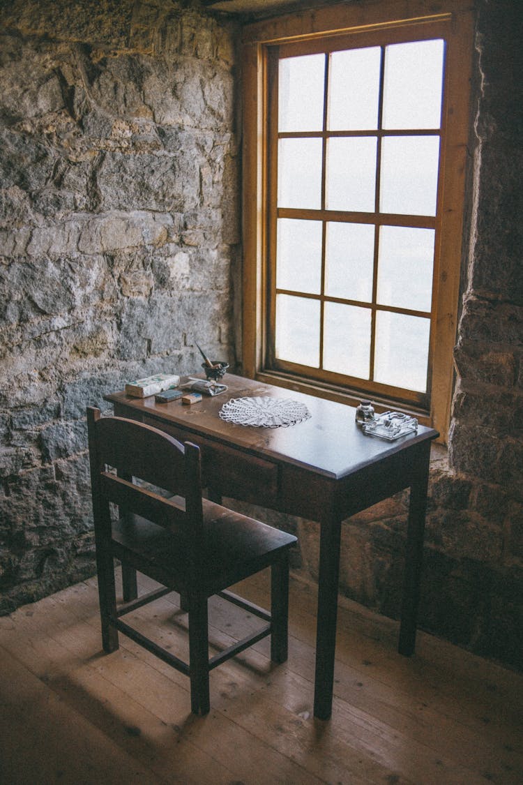 Vintage Study Desk In Corner Of Room With Stone Walls