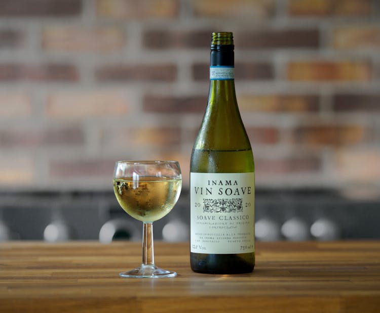 Selective Focus Of Inama Vin Soave Bottle And A Wine Glass On Wooden Surface