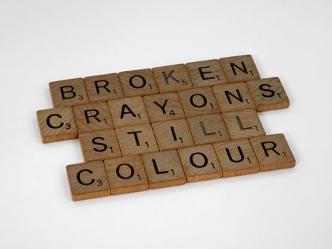 Scrabble tiles spelling 'broken crayons still colour' on a white background.