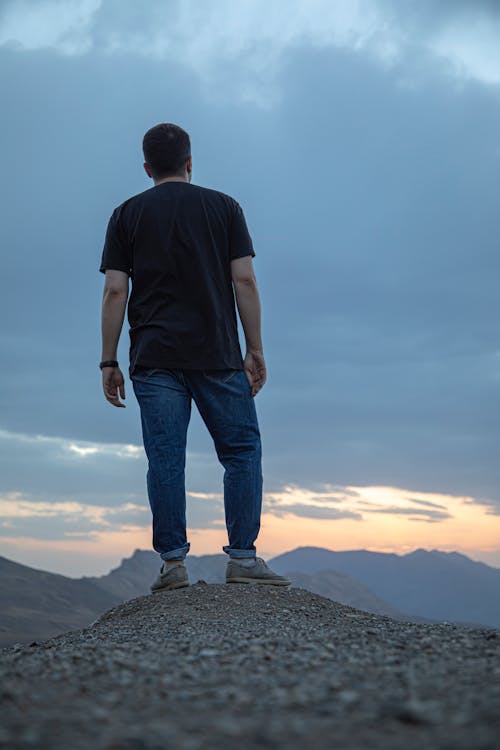 Free Man Wearing a Black T-shirt Standing on Mountain Top Stock Photo