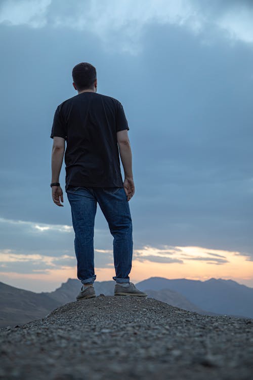 Man Wearing a Black T-shirt Standing on Mountain Top