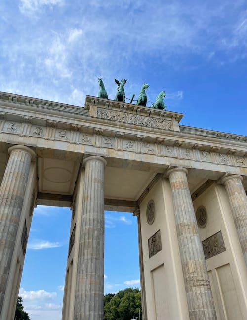 Statues atop Brandenburg Gate against Blue Sky