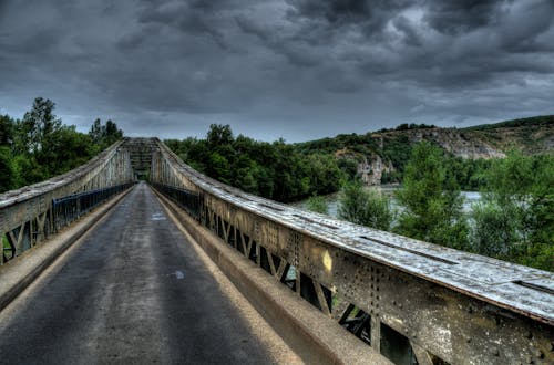 Bridge Beside Mountain Under Gray Clouds