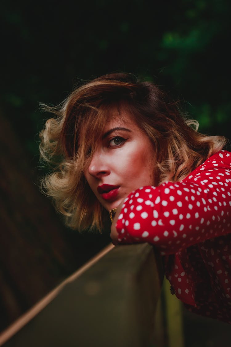 Woman In Polka Dot Shirt Leaning On The Handrail 