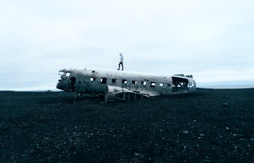 무료 난파 된 비행기에 서있는 사람 스톡 사진