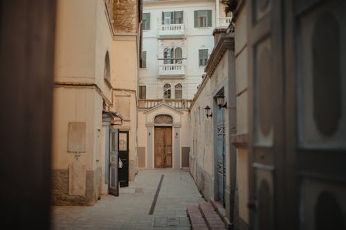 Brown and White Concrete Buildings on the Alley