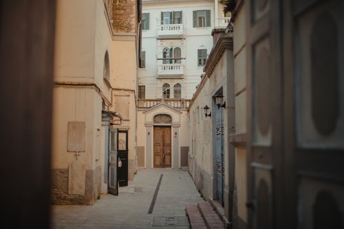 Free Explore a quaint narrow alley lined with historic buildings, showcasing classic architecture and old-town charm. Stock Photo
