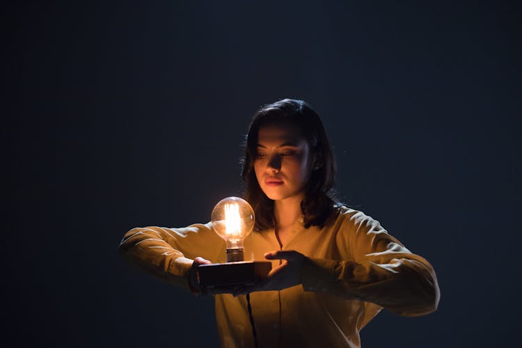 Woman Holding An Incandescent Light Bulb