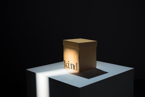 Free A Light Cast on a Cardboard Box with a Kind Note Stock Photo