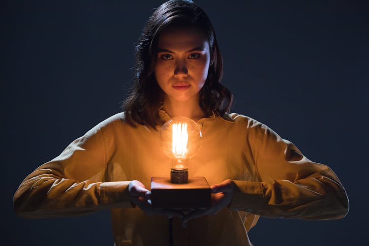 Woman Holding An Incandescent Light Bulb