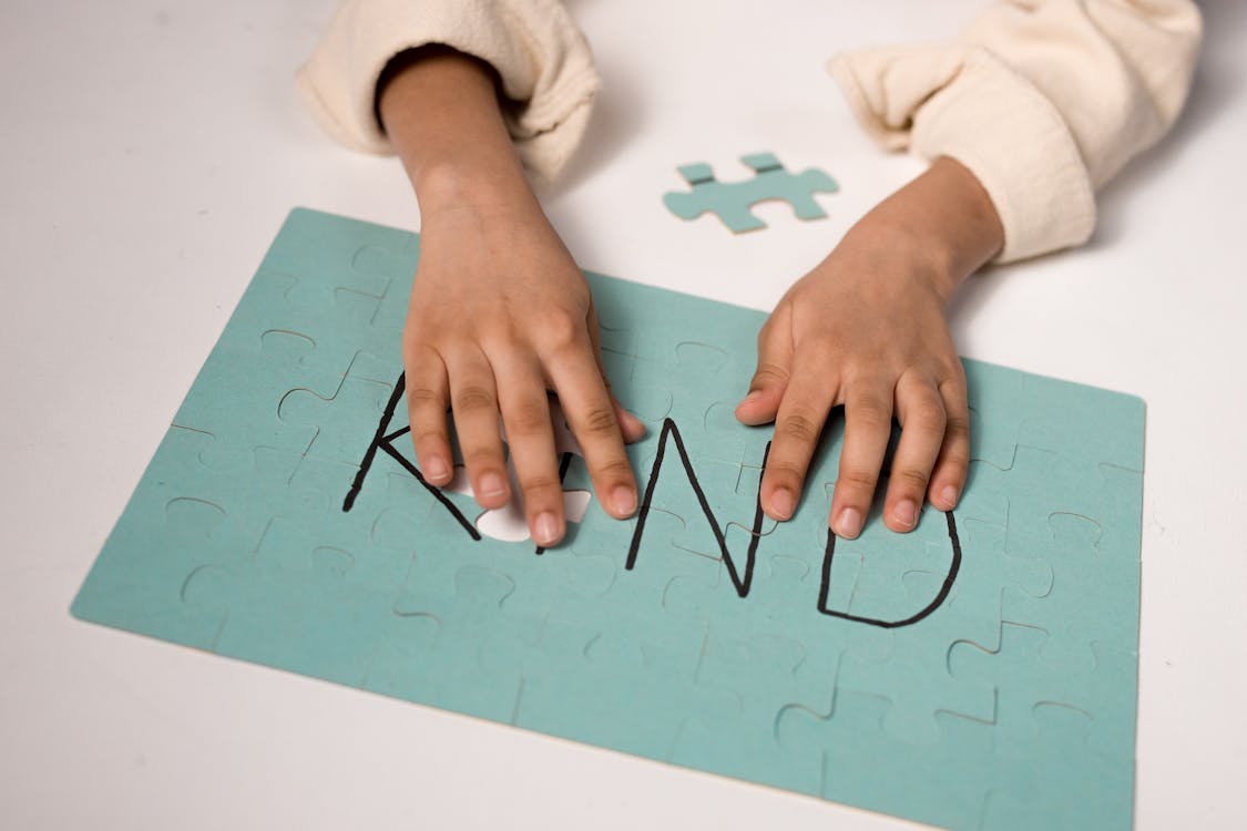 Free Child's Hand on a Puzzle  Stock Photo