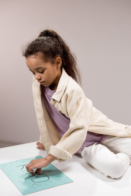 Photograph of a Girl Solving a Jigsaw Puzzle