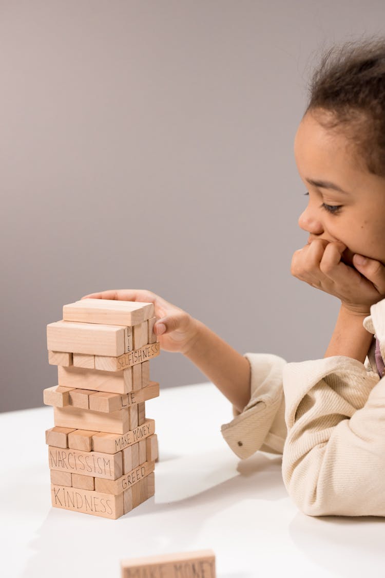 Photograph Of A Girl Playing With Jenga Blocks