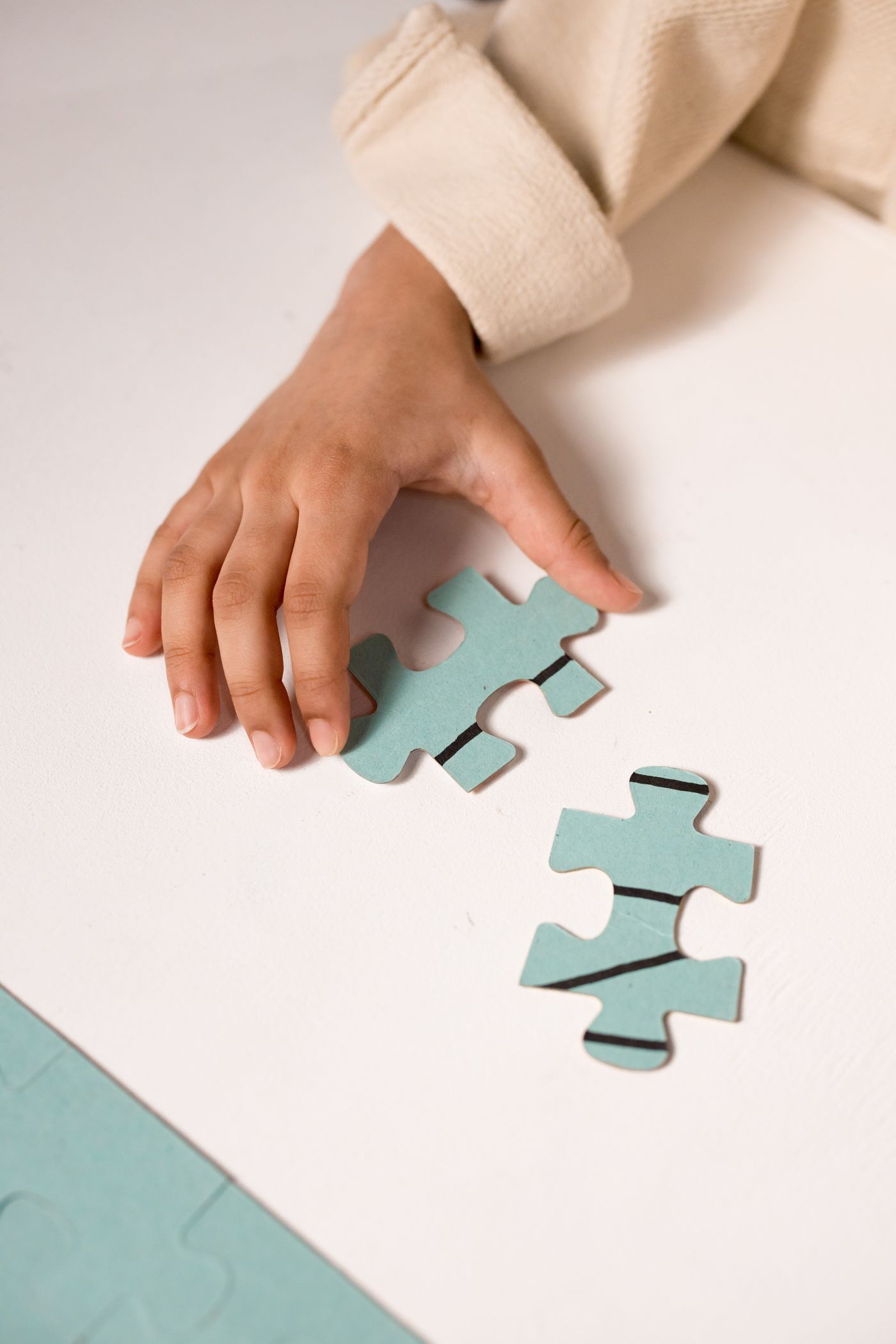 A child's hand focused on solving a puzzle, illustrating concentration and cognitive development.