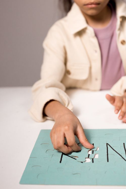 Free Close-up of child engaging with a puzzle, fostering problem-solving skills. Stock Photo