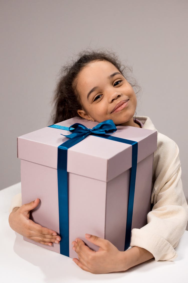 Photograph Of A Girl Holding A Gift Box