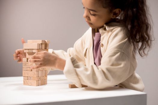 A Girl Playing with Wooden Building Blocks with Words