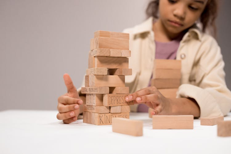 Photo Of A Girl Touching Jenga Pieces