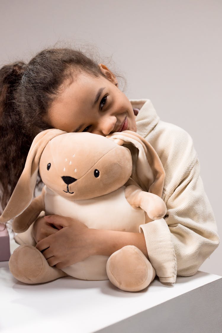 A Girl Hugging A Stuffed Toy