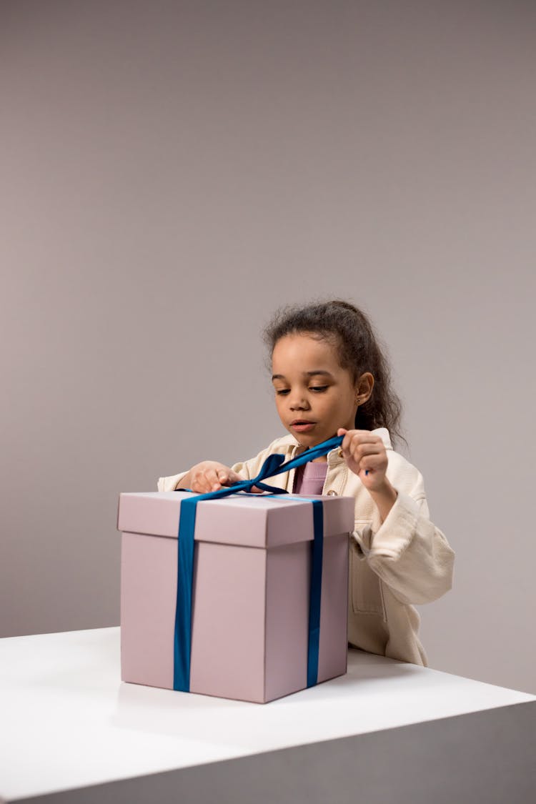 Girl Untying The Ribbon Of The Box