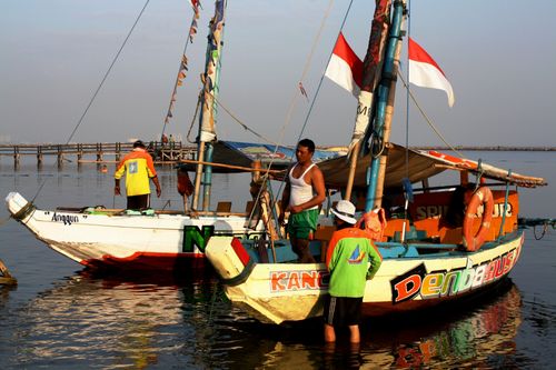 Free Colorful boats with people docked by the sea under morning light, showcasing a lively maritime scene. Stock Photo