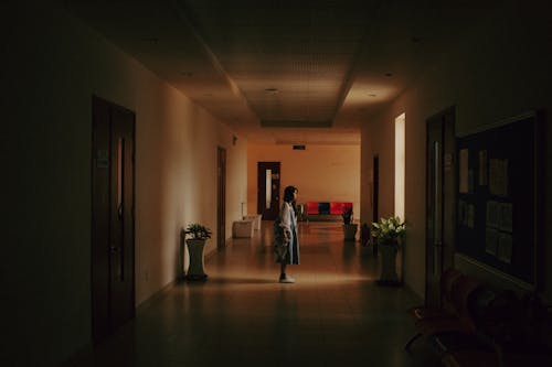 Free Woman Standing Alone in the Hallway Stock Photo
