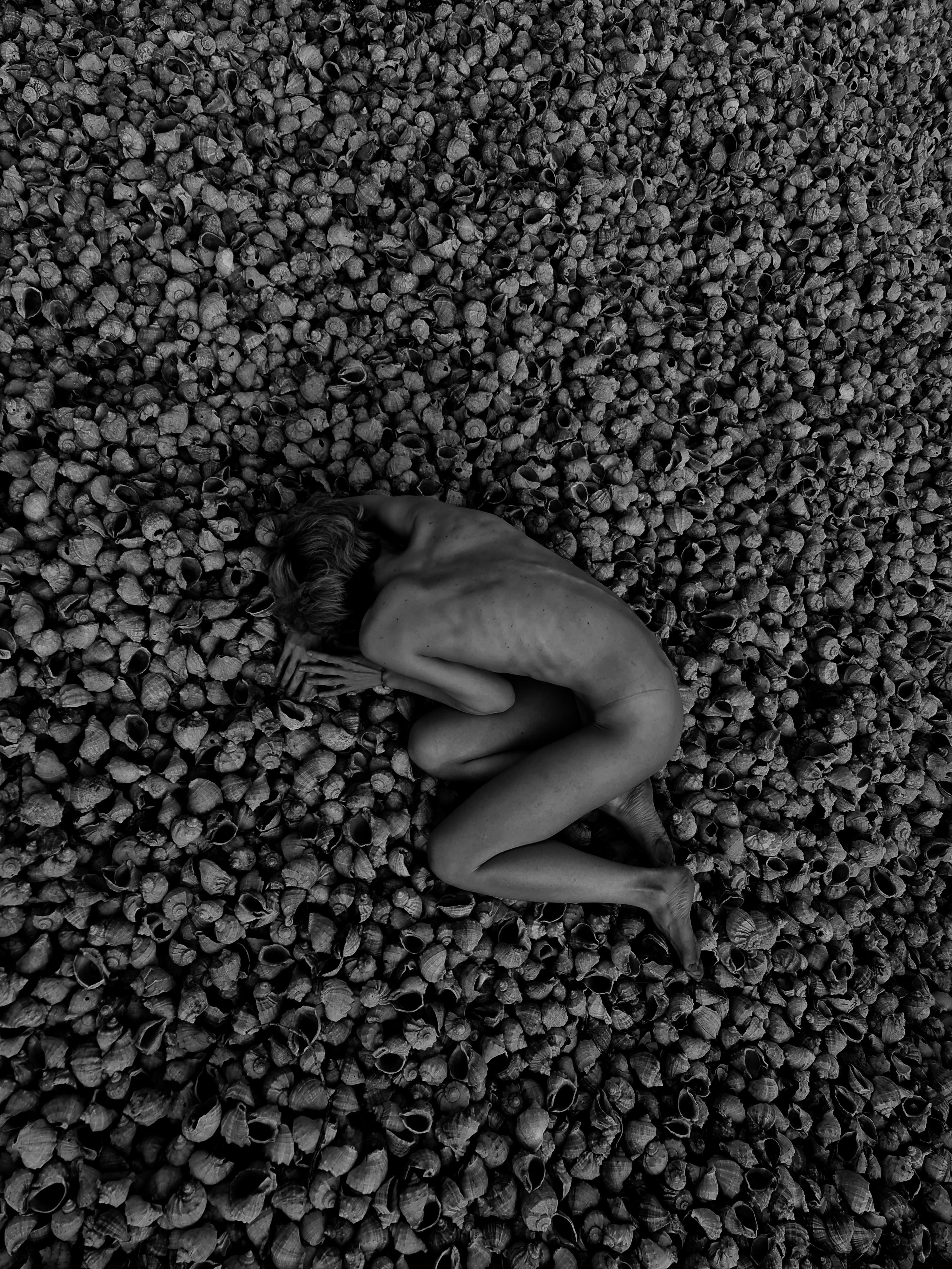 grayscale photo of a person lying on the ground