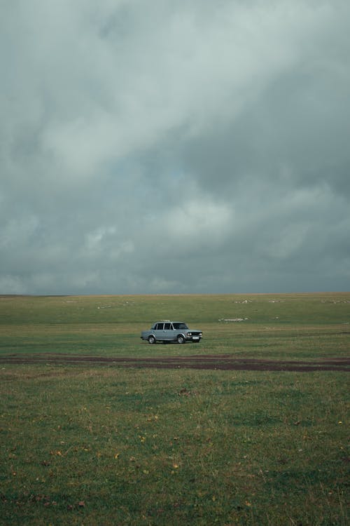 Immagine gratuita di auto, campo, cielo coperto