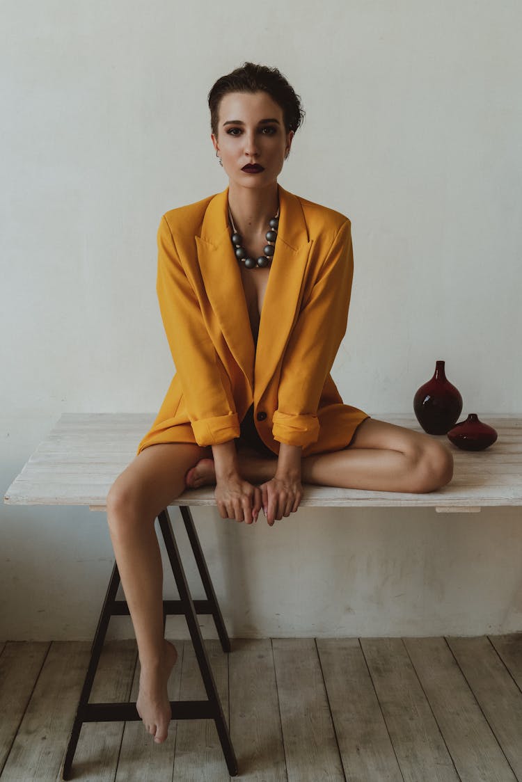 Glamour Woman In Blazer Sitting On Table