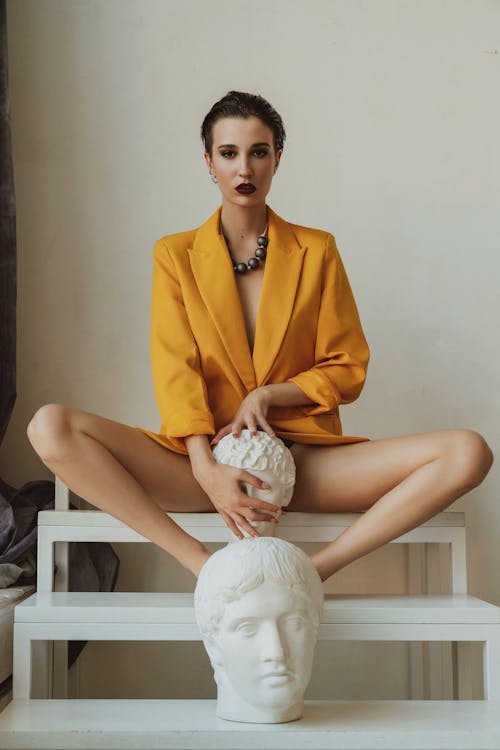 Woman Sitting with Sculpture of Head Between her Legs