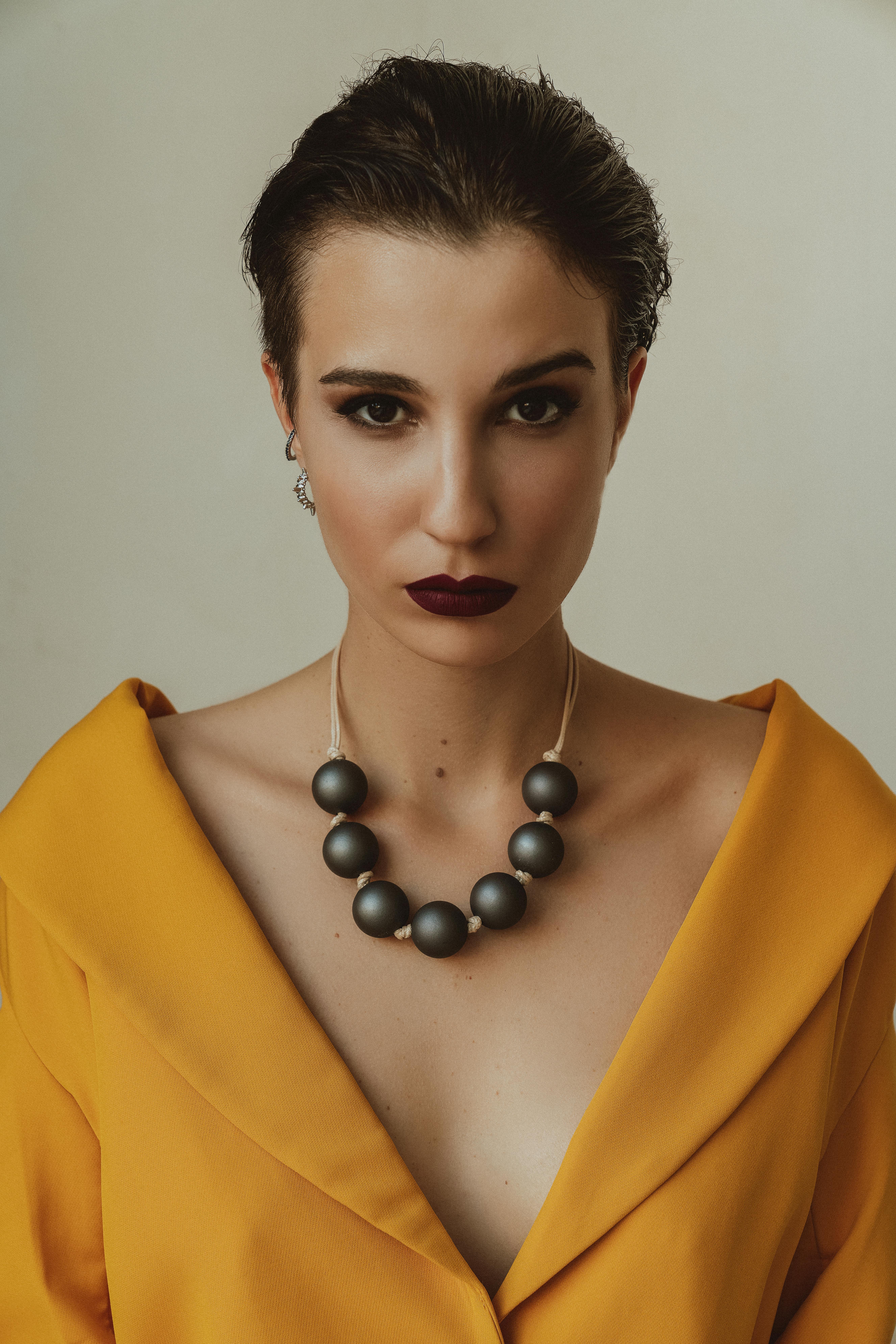 Free Woman with Black Pearl Necklace and Yellow Dress Stock Photo