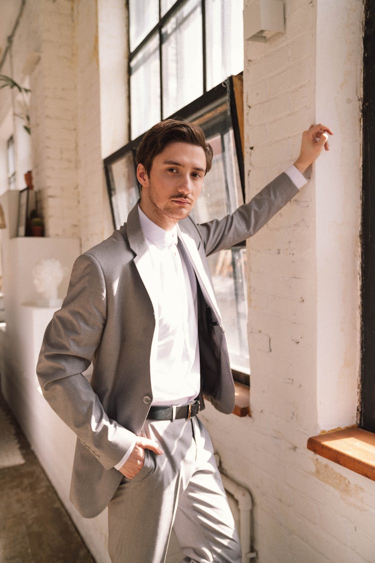 Man In Gray Suit Standing By The Wall