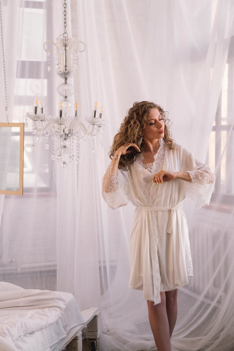 Woman In White Laced Robe Standing Beside White Curtain