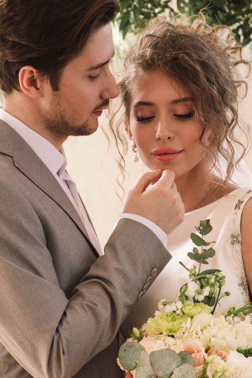 Free Elegant couple in wedding attire sharing a tender moment filled with love and romance. Stock Photo