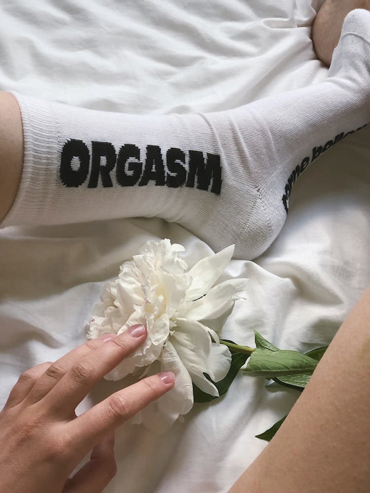 A White Peony Flower Near A Person's Foot