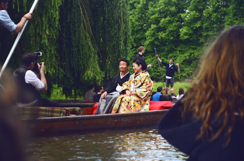 Man and Woman Sitting on Brown Canoe