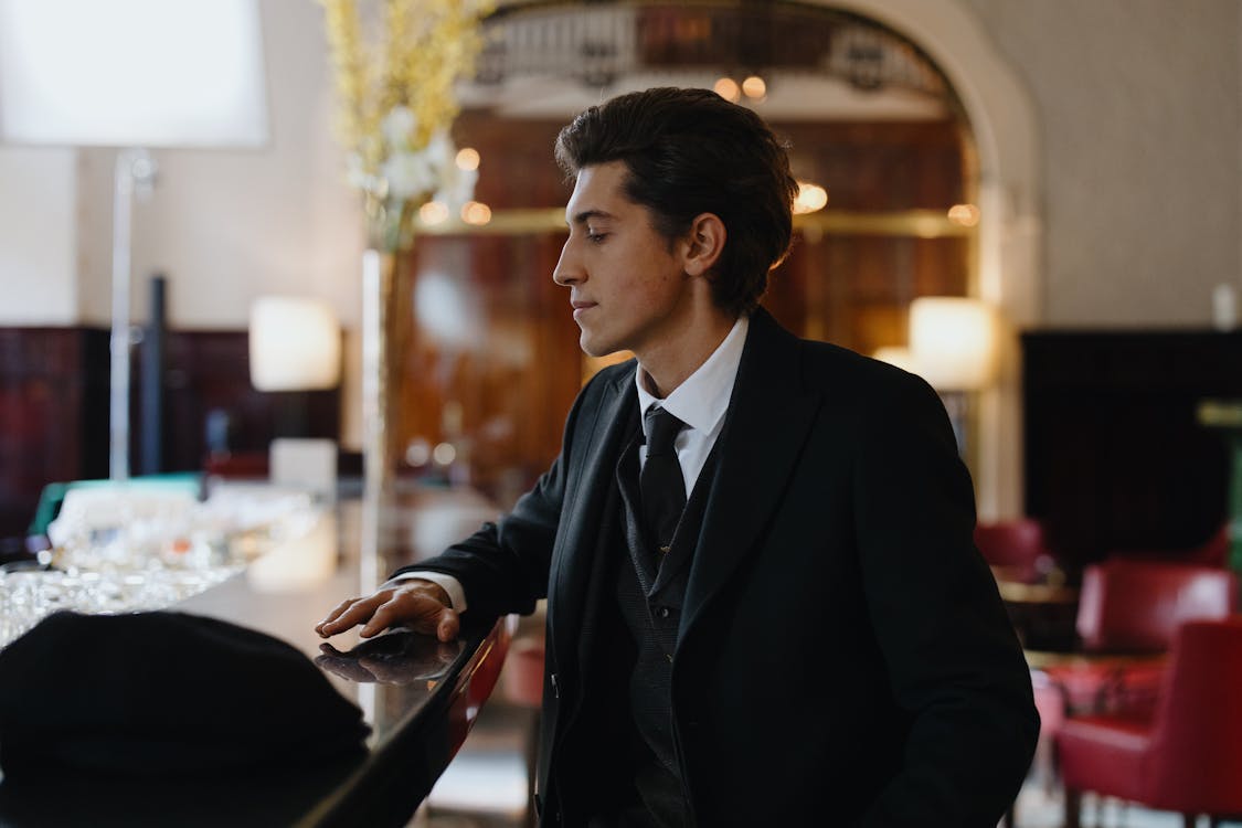 Handsome Man in Black Suit Sitting at the Bar Counter