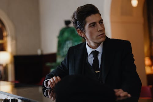 หนุ่มสูทดำในท่านั่งสง่างาม