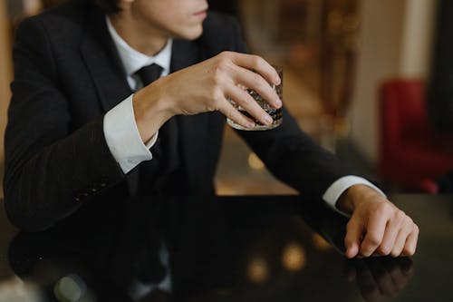 Close-Up Shot of a Person Holding a Glass of Whisky