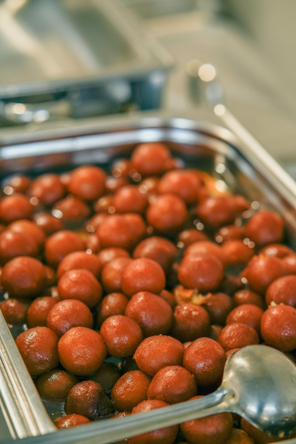 Warm gulab jamun soaked in saffron syrup