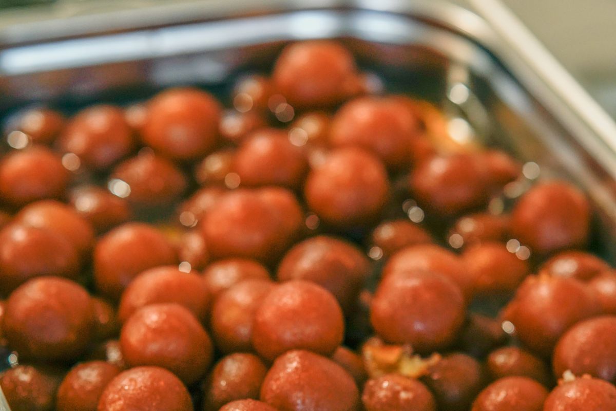 Mouthwatering close-up of traditional Indian dessert gulab jamun soaked in syrup, perfect for food photography.
