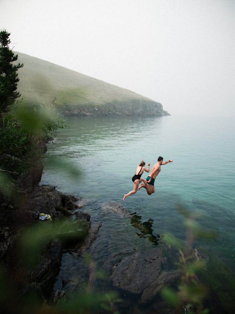 Man And Woman Jumping Off To Water 