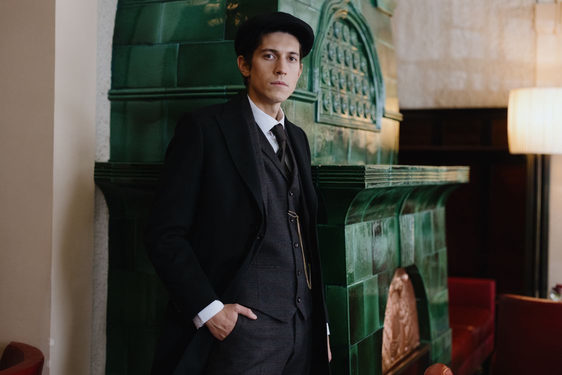 Man in a Suit Standing next to a Fireplace · Free Stock Photo
