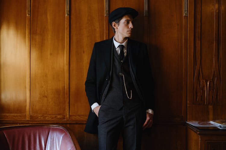 Man In A Suit Leaning Wooden Wall