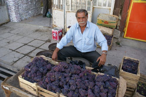 Free Man Selling Fresh Grape Fruits on the Street Stock Photo