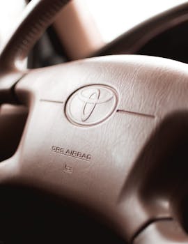 Detailed view of a Toyota steering wheel showing the emblem and airbag label.