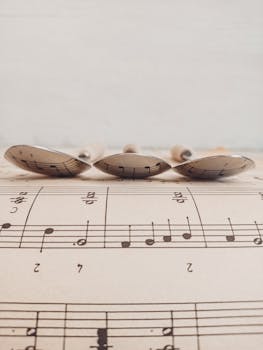 Artistic arrangement of spoons reflecting musical notes on sheet music, creating a unique composition.